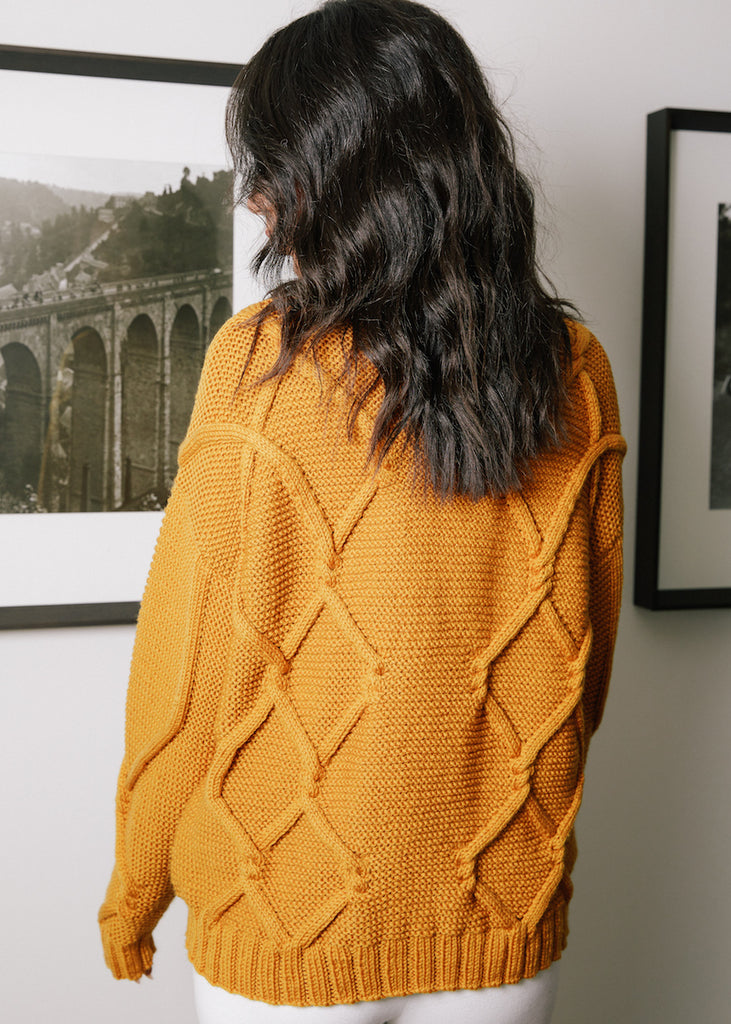 Travelling cable jumper, knitted in one to underarm.